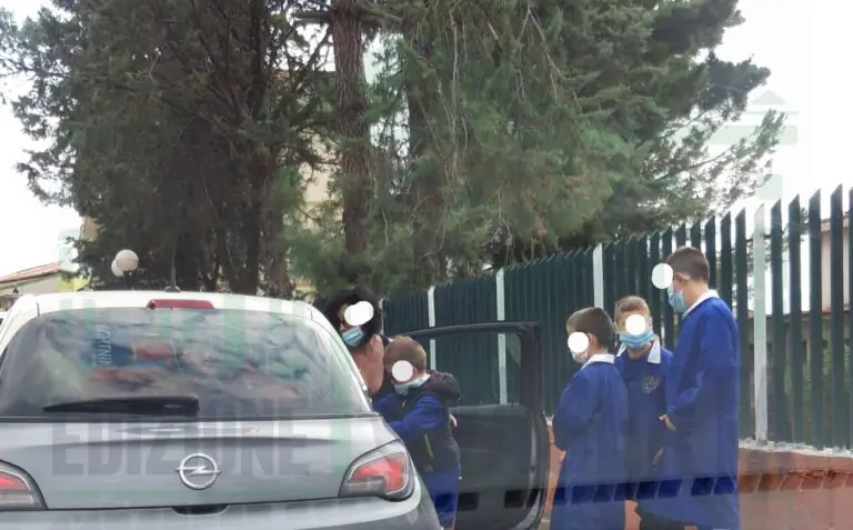 Bambini escono dalla scuola e vengono caricati in auto a sei alla volta