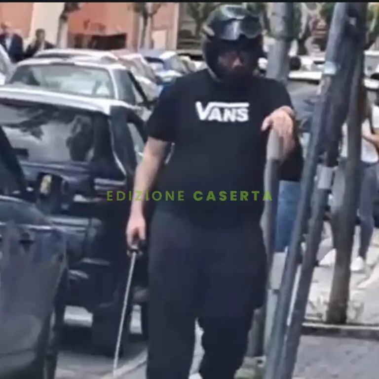 Uomo munito di casco sguaina una sciabola fuori il liceo casertano davanti agli studenti