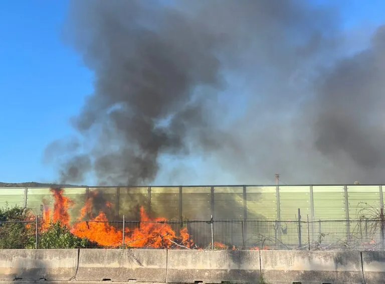 Deposito di rifiuti in fiamme accanto all’autostrada