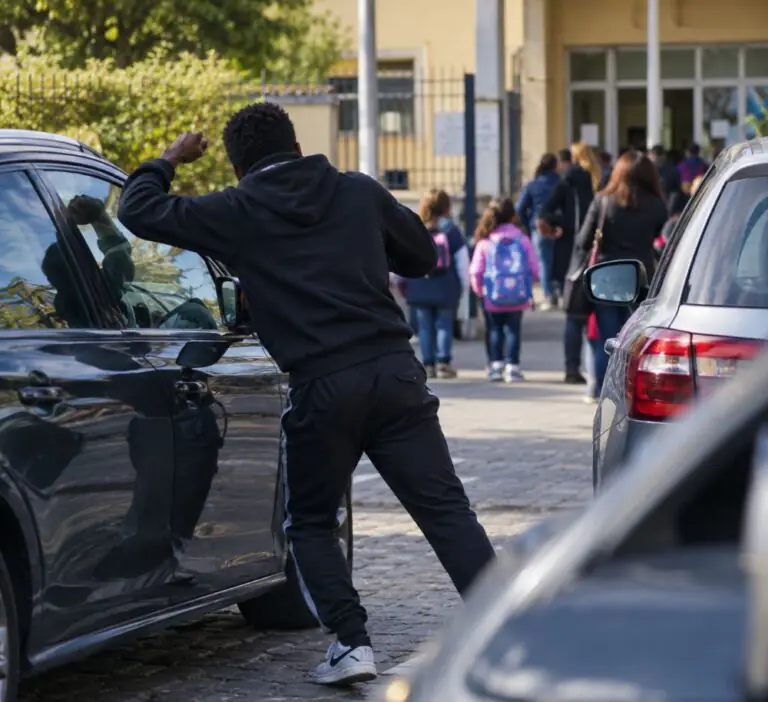 Prende a pugni le auto e urla, paura fuori scuola